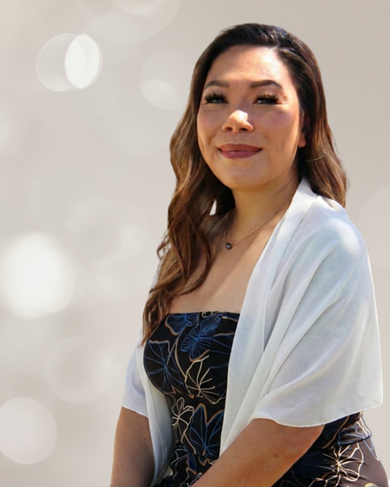 Mandy, founder of Aloha Architect, smiling in a Hawaiian print dress and white shawl